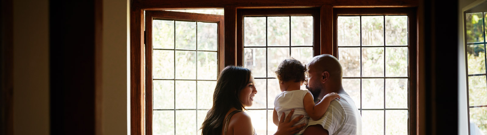 Young family of three looking out the window